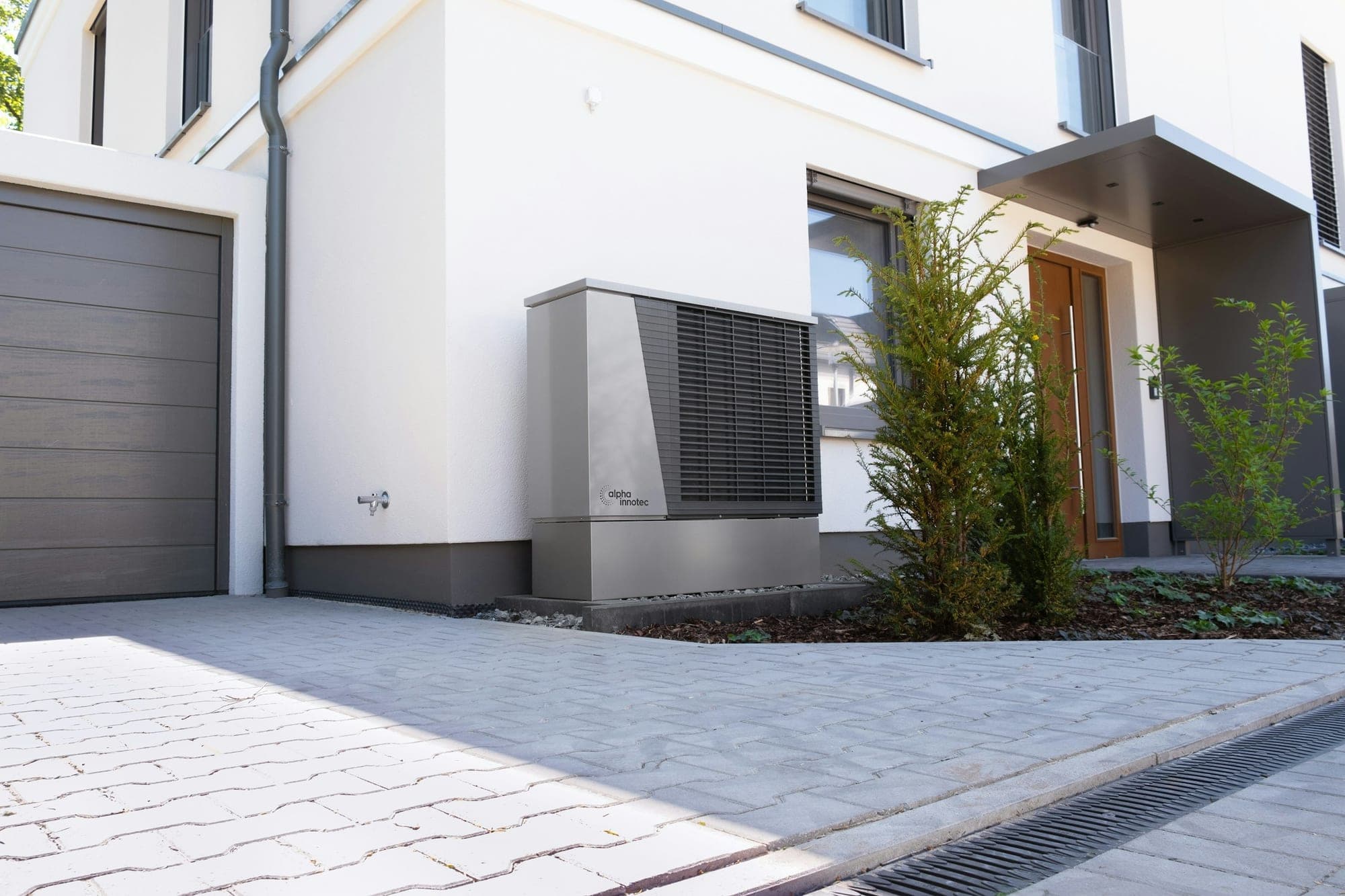 Technicien mettant en service une pompe à chaleur murale dans un salon lumineux