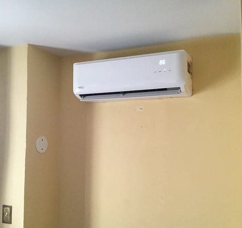Pompe à chaleur murale neuve installée proprement sur un mur clair