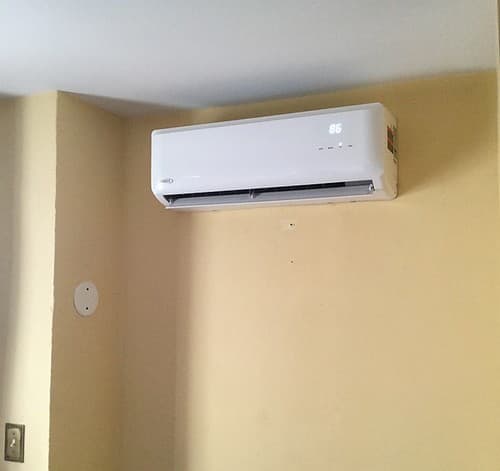 Thermopompe murale neuve installée proprement sur un mur clair