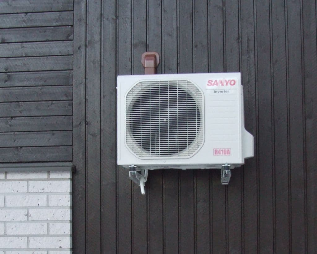 Unité extérieure de thermopompe installée le long d'une maison